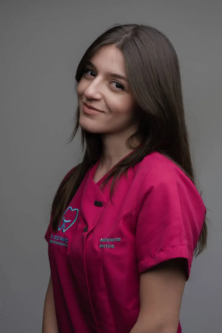 Assistente dentale sorridente in uniforme fucsia