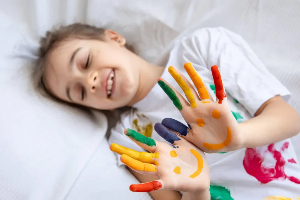 Bambino con mani dipinte sorridenti