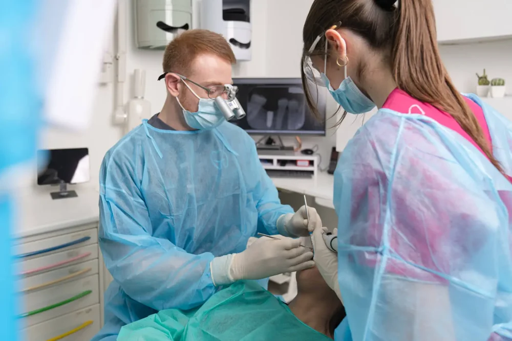Dentista al lavoro con assistente