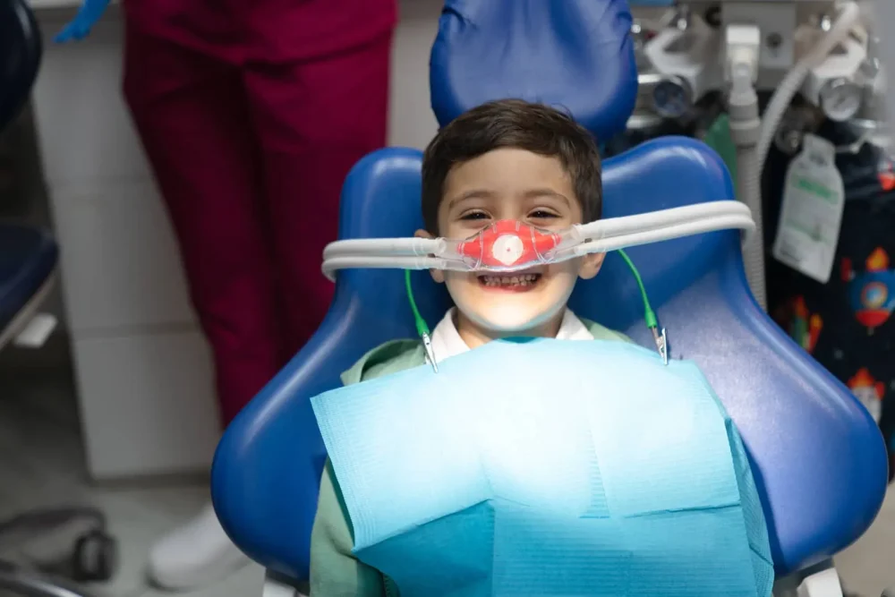Bambino sorride su sedia dentistica